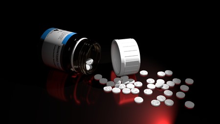 Small white drug pills and a thick glass drug bottle on a table with deep and sharp shadows and a...