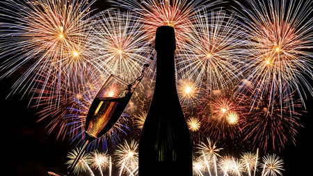 Champagne bottle and fireworks on the black sky background with space for textの素材