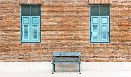 Wooden window shutter and chair iron color cyan with traditional brickwork exterior wall.の写真素材