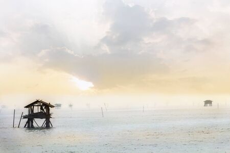 Traditional houses fisherman Built from bamboo in the sea during sunrise and foggy at the river mouth before entering the big sea.の写真素材