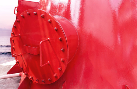 Steel fuel pipes red color with fittings joint with screws and nuts for oil and gas pipeline a the sea background.の写真素材