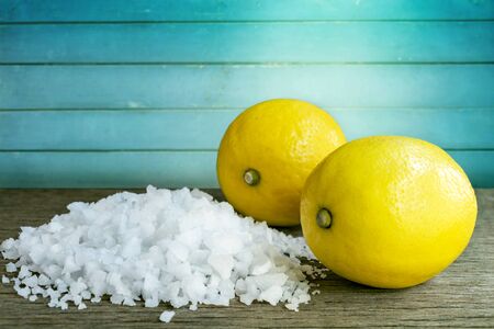 Lemon and sea salt - Beauty treatment with organic cosmetics with lemon ingredients on wood background for body scrub and spa care.の写真素材