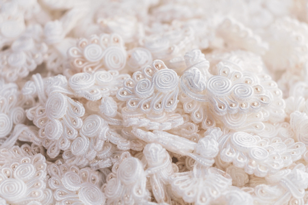 Button knot chinese : A lot of  traditional chinese white knot buttons on the white background.の写真素材