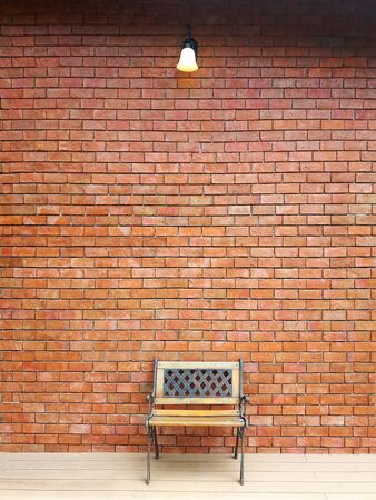 Vintage chair iron and wooden with traditional red brick wall exterior wall. Surface texture masonry bright cleaned brickwork background.の写真素材