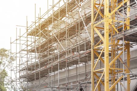 Construction scaffolding as temporary structure for support safety in construction site for new...