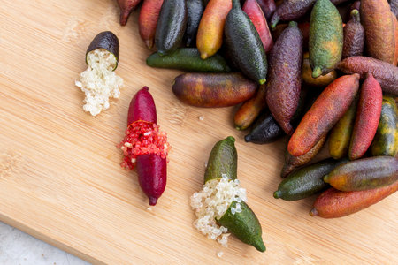 Finger lime or caviar lime of Australian cut in half, it is edible fruits used for cooking gourmet cuisine. Fresh Citrus australasica on wood background.の写真素材