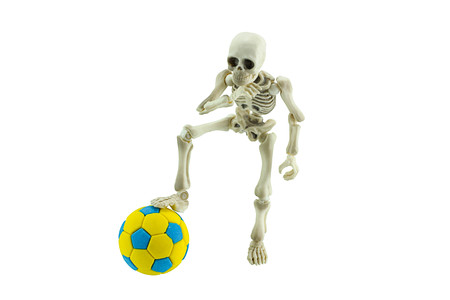 Skeleton with soccer ball isolated on white concept of football never die.