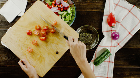 table with vegetables and cutting tomatos on the board top viewの写真素材