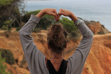 woman with love gesture in the nature