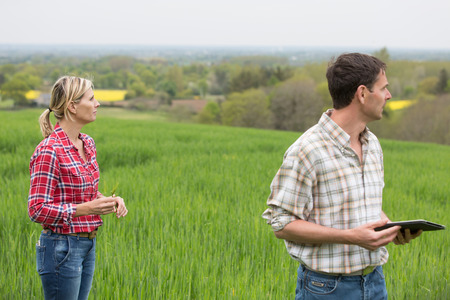 Female farmer speaking with agronomist technicianの写真素材