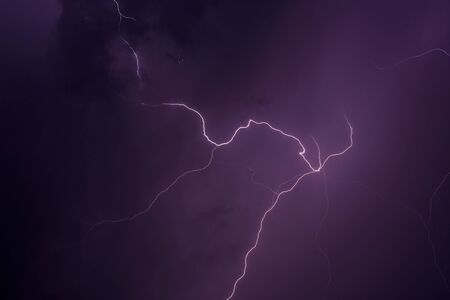 Lightning thunderstorm flash over the night sky.の写真素材