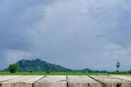 A wooden table resting on the meadow, The shelf has a mountain view on the frontの写真素材