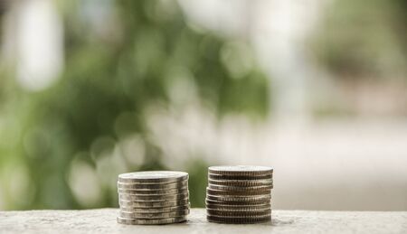 Ten Thai Baht coins and five Thai coins stacked with green backgrounds.の写真素材
