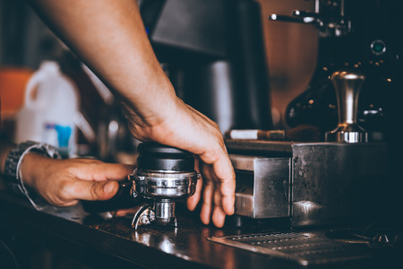 Barista hold portafilter and coffee tamper make coffee in coffee shop or cafe.の写真素材