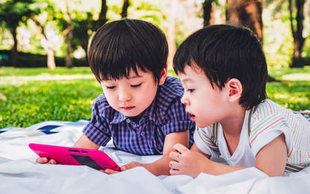 little kids boy cute schoolboy fun and enjoying playing and using digital tablet .の写真素材