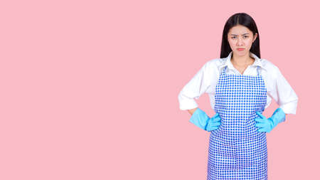 Portrait asian beautiful woman wearing apron and rubber gloves for cleaning , Housekeeper standing with products and equipment cleaner.の写真素材