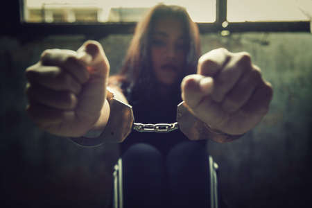 violence crime and kidnapping people concept, criminal tying woman hands with handcuffs.の写真素材