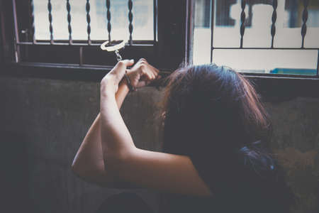 violence crime and kidnapping people concept, criminal tying woman hands with handcuffs.の写真素材