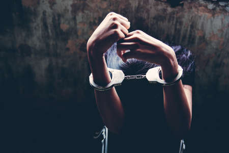 criminal tying hands with handcuffs.の写真素材