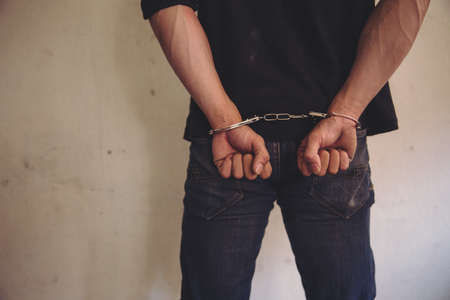 criminal tying hands with handcuffs.