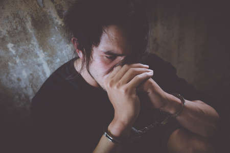 criminal tying hands with handcuffs.の写真素材