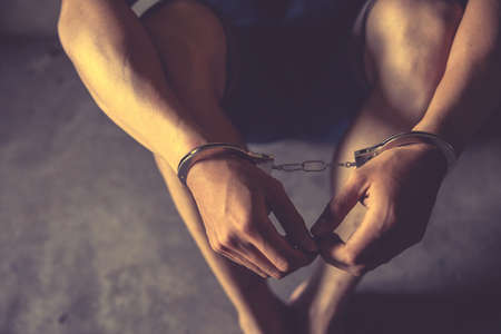 criminal tying hands with handcuffs.の写真素材