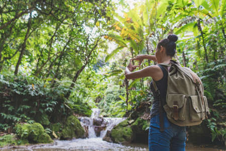 young girl taking photo flower in garden journey backpack.