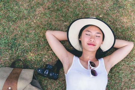 young girl taking photo flower in garden journey backpack.の写真素材