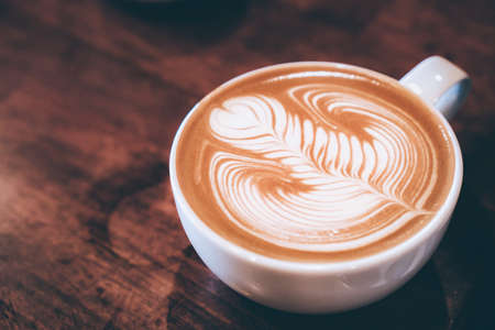 coffee latte art on wood table, relax time, cafe barista art top view.
