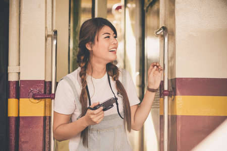 asian young girl taking photo, happy traveler by the train.