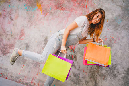 Happy shopper asian woman holding a shopping bagの写真素材