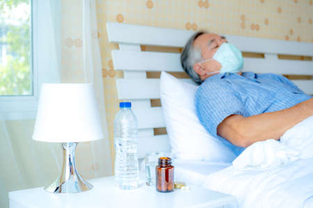 Happy old man positive, Portrait Asian Senior man and eyeglasses using computer laptop in bedroom at home, Old elderly male Technology communication retirement lifestyles concept.の写真素材