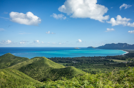The lush green mountains and beautiful turquoise ocean water of Waimanalo Bay, Hawaii, as seen from the top of the Lanikai Pillbox hike.の写真素材