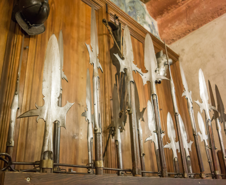 A wooden rack of assorted spears, halberds, and other medieval bladed weaponry.の写真素材