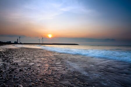 Reflection of the sunset and windmill の写真素材