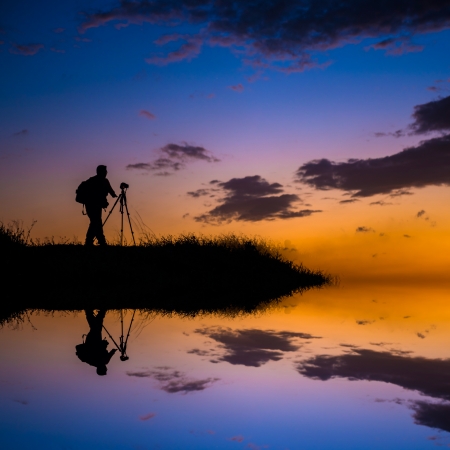 Dream place for photo take, the person is mirrored below with a soft pastel sunset sky as backdrop の写真素材