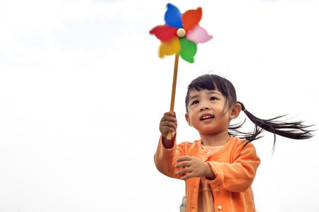 cute little girl in summer day holds windmillの写真素材