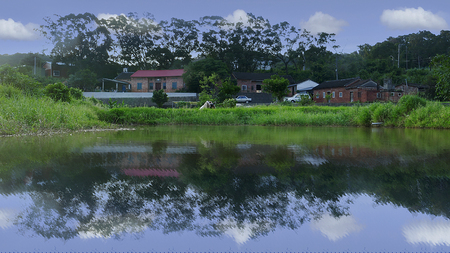 The beautiful old house with nice blue sky and reflection on the pondの写真素材