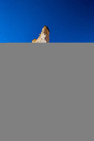 Close up against pillar of white rock in flat desert with vibrant blue skyの写真素材