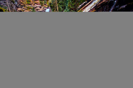 Majestic falls in background with cascading falls over red rocks in frontの写真素材