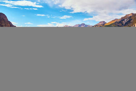 Open view of large mountain valley with lush green and yellow fall forestの写真素材