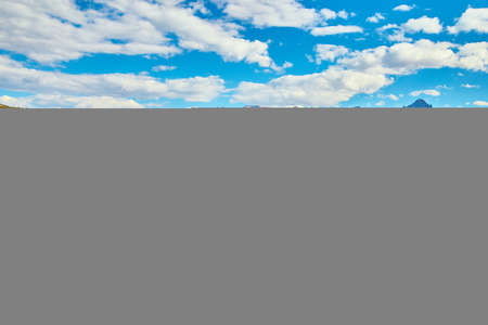 Open field with wood fence and lone tree with beautiful mountain range in backgroundの写真素材