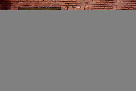 Window on a red brick wall with teal accentの写真素材