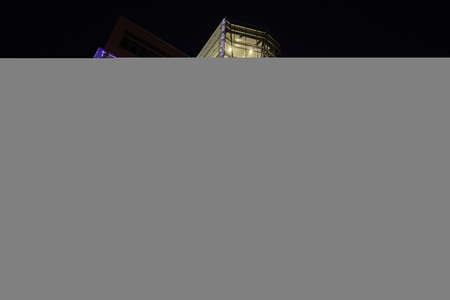 Parking garage at night in city with blue and yellow lightsの写真素材