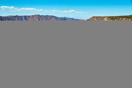 Large canyon with brown cliffs and wavy blue riverの写真素材