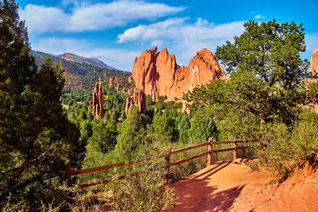 Walking path with wood fence and desert mountain view of larger pillars of red rockの写真素材