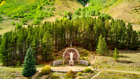 Jesus Christ of the Mine statue of respect in the mountains surrounded by pine treesの写真素材