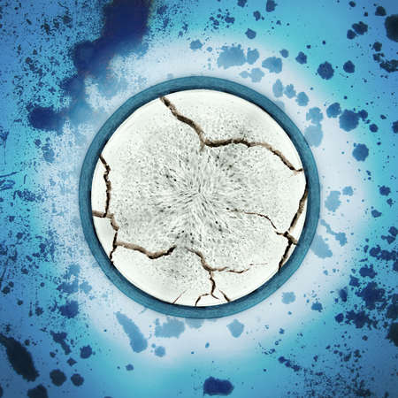 Abstract textured white cracking circle superimposed on a blue speckled surfaceの写真素材