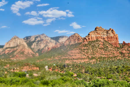 Arizon landscape of large red mountains green trees and blue skyの写真素材
