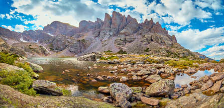 Panorama of lake at the top of mountains with sharp peaksの写真素材